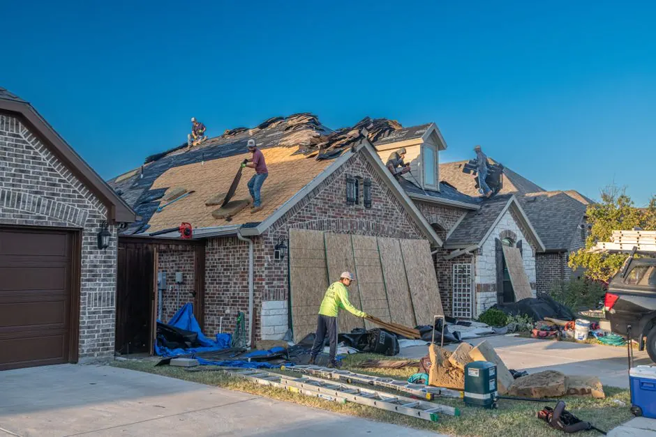 Workers engage in roof replacement on a brick house in Fort Worth, Texas.